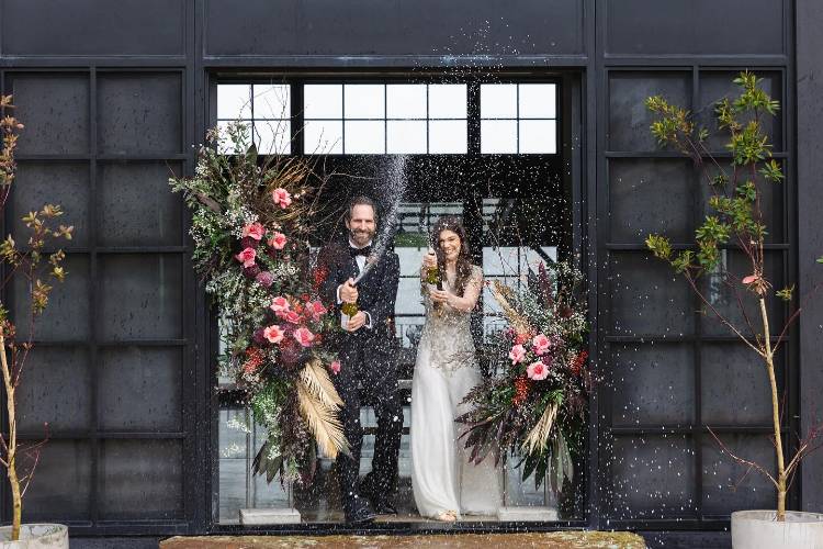 Newly married couple popping champagne by Albury wedding planner Enhance Styling