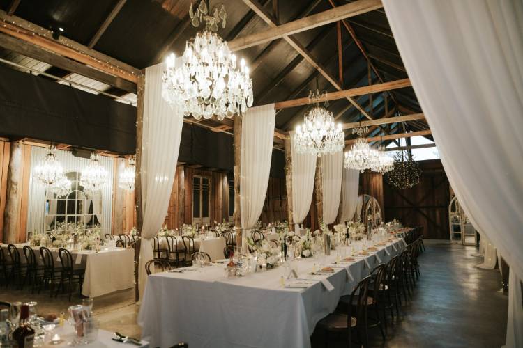 Luxury reception venue near Sydney that features chandeliers in a rustic barn