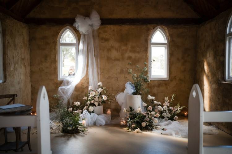 Chapel wedding ceremony styled with flowers & draped fabric